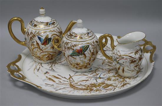 A porcelain four piece teaset, decorated with butterflies